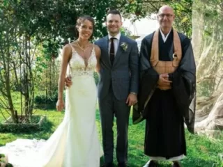 Zen Vater Meister Reding posiert als Hochzeitsredner und Trauredner f&uuml;r die freie Trauung neben dem Ehepaar im Garten nach der Hochzeitszeremonie